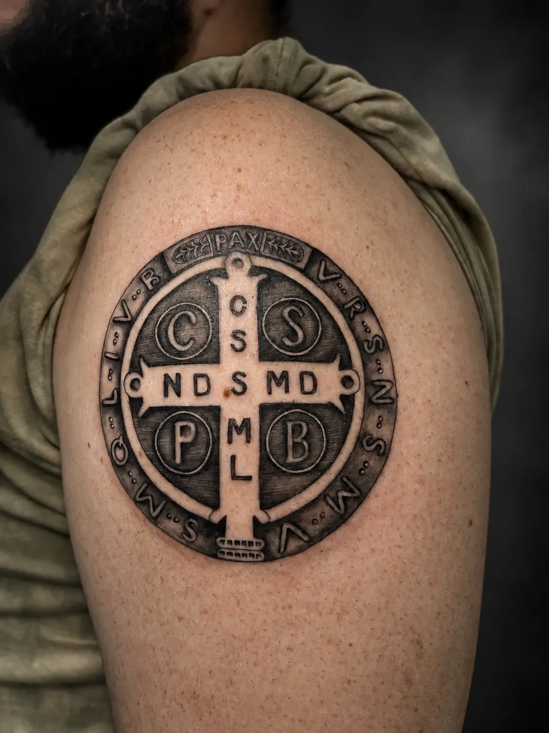 Tatuagem da medalha de São Bento no ombro